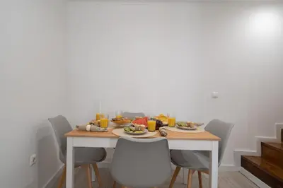a dining room table with plates of food and orange juice at Authentic Porto Home by HostWise in Porto