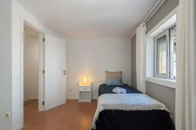 a small bedroom with a bed and a window at Authentic Porto Home by HostWise in Porto