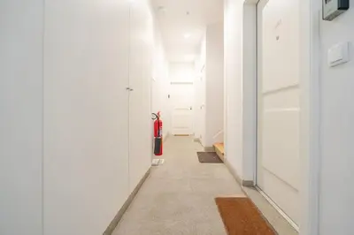 a hallway with white walls and a red fire extinguisher at Bright & Characterful Home by HostWise in Porto