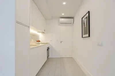 a kitchen with white walls and a white tile floor at Bright & Characterful Home by HostWise in Porto