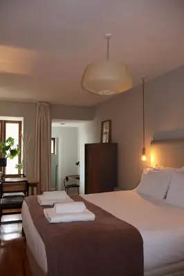 a hotel room with a large bed and a chair at Porto Central Apartment in Porto