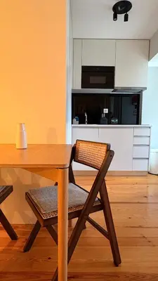 a wooden table with a chair and a kitchen at Porto Central Apartment in Porto