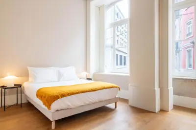 a bedroom with a bed and a large window at Entreparedes House in Porto