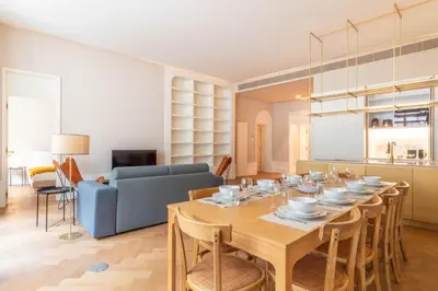 a dining room with a table and a blue couch at Entreparedes House in Porto