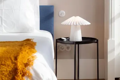 a table with a lamp on it next to a bed at Entreparedes House in Porto