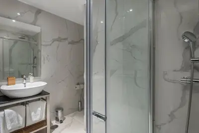 a bathroom with a glass shower and a sink at GuestReady - Bahl Apartments in Porto