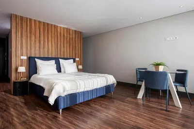 a bedroom with a bed and a table and chairs at GuestReady - Bahl Apartments in Porto