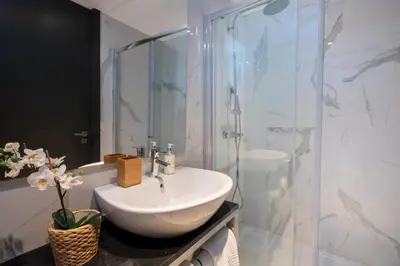 a bathroom with a sink and a glass shower at GuestReady - Bahl Apartments in Porto