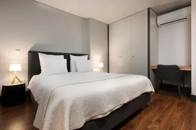 a bedroom with a large white bed and a desk at GuestReady - Bahl Apartments in Porto