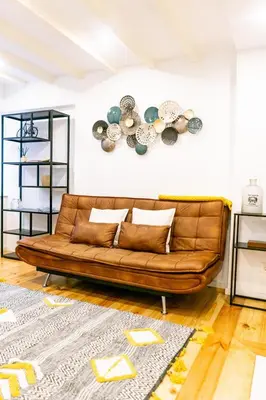a brown leather couch in a living room at Magnificent Cais de Gaia Duplex in Vila Nova de Gaia