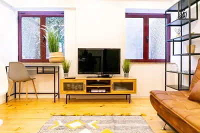 a living room with a television and a couch at Magnificent Cais de Gaia Duplex in Vila Nova de Gaia
