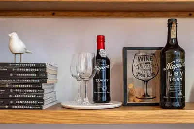 a shelf with two bottles of wine and a glass at City Center Lello and Clerigos 5min Walk with Free Parking in Porto