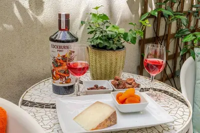 a table with a plate of food and two glasses of wine at City Center Lello and Clerigos 5min Walk with Free Parking in Porto