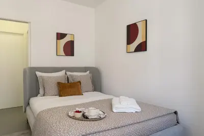 a bedroom with a bed with a tray of food on it at Bonfim Charming Flats by HostWise in Porto