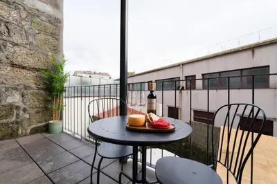 a table with a plate of food on a balcony at Bonfim Charming Flats by HostWise in Porto