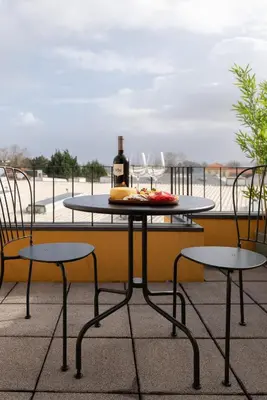 a table with a bottle of wine and two chairs at Bonfim Charming Flats by HostWise in Porto