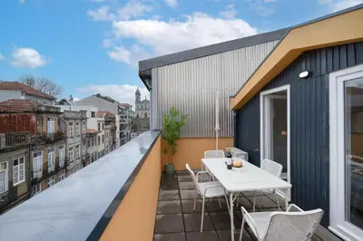 a balcony with a white table and chairs on a building at Bonfim Charming Flats by HostWise in Porto