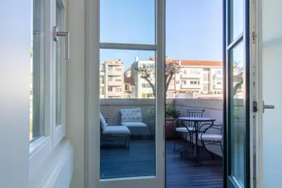 a sliding glass door to a balcony with a table and chairs at Deluxe Design 1BR w Terrace by LovelyStay in Porto