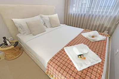 a bedroom with a large white bed with towels on it at ON Apartments - Family - Free Parking & Pet Friendly in Porto