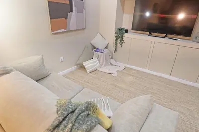 a living room with a white couch and a flat screen tv at ON Apartments - Family - Free Parking & Pet Friendly in Porto