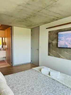 a bedroom with a bed with a tv on the wall at Skyline Heaven - Fantastic View - Pool - Garage in Vila Nova de Gaia