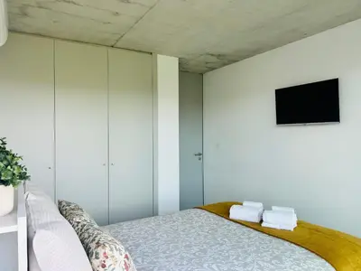 a bedroom with a bed and a tv on the wall at Skyline Heaven - Fantastic View - Pool - Garage in Vila Nova de Gaia