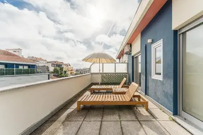 a patio with two chairs and an umbrella on a balcony at GuestReady- Charming Porto Retreat with Terrace in Porto