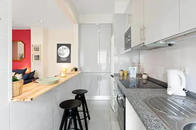 a kitchen with two bar stools and a counter top at GuestReady- Charming Porto Retreat with Terrace in Porto