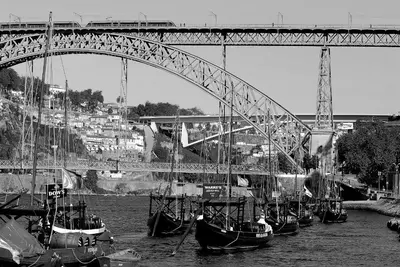 a group of boats in the water under a bridge at Welcome to my city 2 in Porto