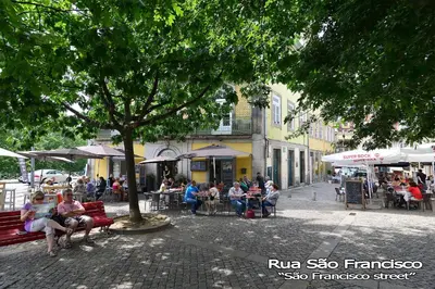 a group of people sitting on benches on a city street at Welcome to my city 2 in Porto