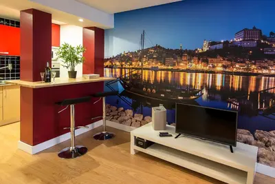 a living room with a tv and a painting of a city at Welcome to my city 2 in Porto