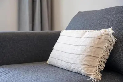 a pillow sitting on top of a gray couch at GuestReady - Elegant stay in Central Porto in Porto