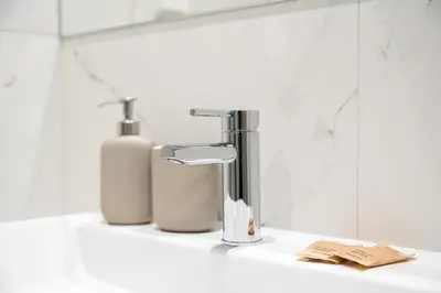 a bathroom sink with a faucet and two soap bottles at GuestReady - Elegant stay in Central Porto in Porto