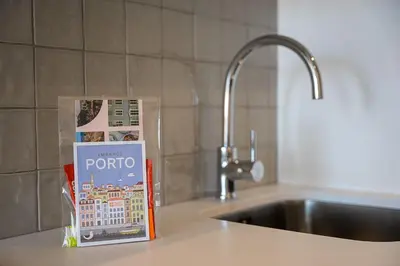 a book sitting on a kitchen counter next to a sink at GuestReady - Elegant stay in Central Porto in Porto