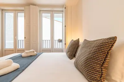 a bedroom with a white bed with two pillows at Oporto Center Studio in Porto