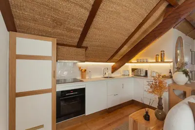 a kitchen with white cabinets and a wooden ceiling at The Terraced Loft - Boho Elegance in Porto in Porto