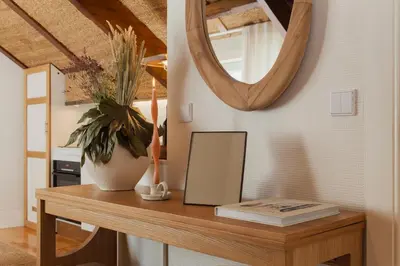 a mirror and a vase on a wooden table at The Terraced Loft - Boho Elegance in Porto in Porto