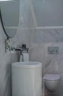 a white bathroom with a toilet and a mirror at The Dome in Porto