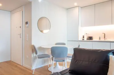 a living room with a table and chairs and a kitchen at Golden Comfort CasaBela 7 Star by LovelyStay in Porto