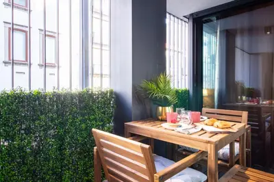 a wooden table with food and drinks on a patio at Golden Comfort CasaBela 7 Star by LovelyStay in Porto