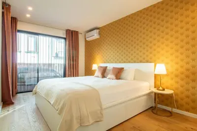 a bedroom with a white bed with a yellow wall at Golden Comfort CasaBela 7 Star by LovelyStay in Porto