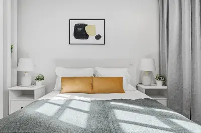 a white bedroom with a bed and two lamps at Timeless Porto Studio @ Marquesa Palace in Porto