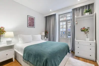 a white bedroom with a bed and a window at Serene Porto Studio @ Marquesa Palace in Porto