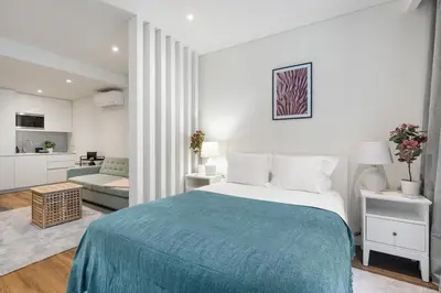 a bedroom with a large bed and a living room at Serene Porto Studio @ Marquesa Palace in Porto