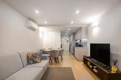 a living room with a couch and a table with chairs at Ribeira Apartments São João in Porto