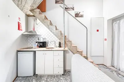 a kitchen with white cabinets and a staircase at GuestReady - Charming Porto retreat in Porto
