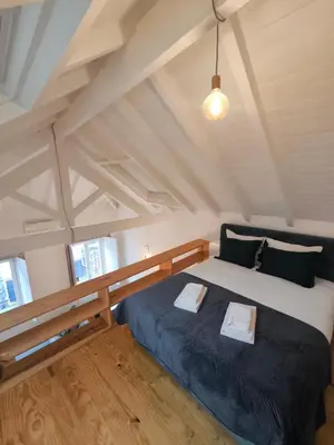 a bedroom with a large bed in a attic at ALMADA LOFT LIVING by We Do Living in Porto