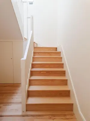 a staircase in a house with wooden floors and white walls at Classic loft in fully renewed building at Batalha in Porto