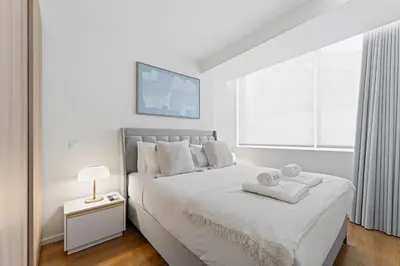 a white bedroom with a bed with towels on it at GuestReady - Marble Branch in Porto