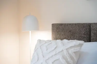 a bedroom with a bed with a lamp and a pillow at GuestReady - Marble Branch in Porto